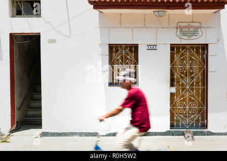 Man riding passé façade de vieille maison à Cienfuegos, Cuba Banque D'Images