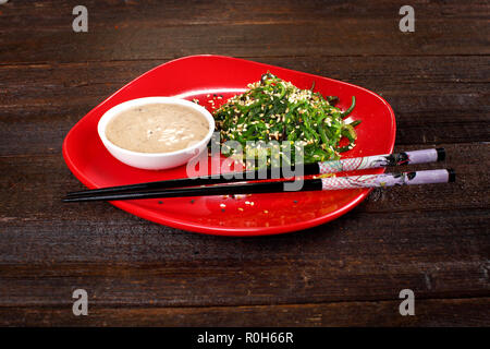 Sauce aux arachides et d'algue nori sur la plaque rouge Banque D'Images