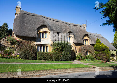 Voir des savoirs traditionnels en pierre de Cotswold cottage de chaume le long Westington en automne après-midi de soleil sentier public Banque D'Images