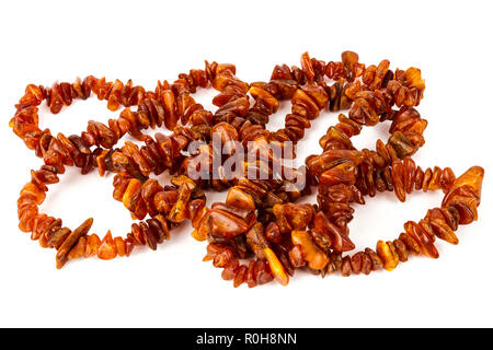 Chaîne de perles d'ambre baltique isolé sur fond blanc. Collier ambre orange vif de matières perles en un tas. Banque D'Images