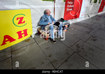 Sans-abri avec son chat sur Oxford Street, Londres, Angleterre, Royaume-Uni. Banque D'Images