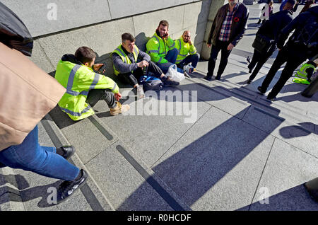 Des ouvriers ayant une pause sur les marches de Trafalgar Square, Londres, Angleterre, Royaume-Uni. Banque D'Images