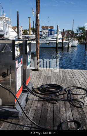 Deux pompes à carburant sur un vieux quai en bois avec différents types de bateaux en arrière-plan. Cette photo n'est disponible pour un usage commercial à condition qu'une trad Banque D'Images