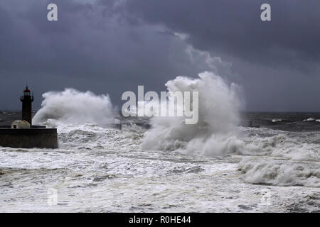 Big White vagues de Piers et phare contre une sombre tempête ciel nuageux. La bouche de la rivière Douro, Porto, Portugal. Banque D'Images