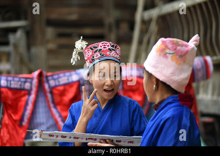 (181105) -- QIANDONGNAN, le 5 novembre 2018 (Xinhua) -- Jialong Sunshine Yang (L) traite de broderie en langue des signes avec sa mère au Village de Xinjiang Taijiang Comté de Qiandongnan Préfecture autonome Miao et Dong, au sud-ouest de la province du Guizhou, en Chine, le 4 novembre 2018. Né avec une perte auditive, Yang, Jialong Sunshine 28, est une femelle de l'ethnie Miao, qui sont engagés dans la broderie Miao au village. Elle a appris la broderie de sa mère alors qu'elle n'était qu'un enfant, et a été un maître bien connu maintenant. (Xinhua/Liu Kaifu) (SXK) Banque D'Images