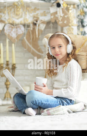 Portrait of teenage girl with headphones using laptop Banque D'Images