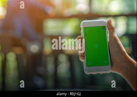 La vue est coupé de la Woman's hand holding a smart phone avec un écran blanc pour l'espace de messages texte ou contenu du message texte lecture sur un mobile p Banque D'Images