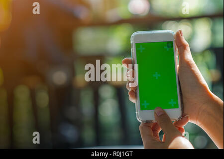 La vue est coupé de la Woman's hand holding a smart phone avec un écran blanc pour l'espace de messages texte ou contenu du message texte lecture sur un mobile p Banque D'Images