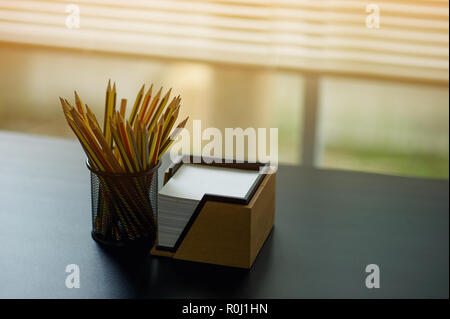 Crayon et note placée sur le bureau exécutif. Placé par la fenêtre Banque D'Images