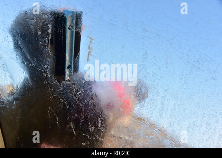 Beaucoup de pays de Galles s'est réveillé ce matin à la couche de givre de surface couvrant les pare-brise de voiture et des températures de gel. retrait de la glace d'un pare-brise de voiture Banque D'Images