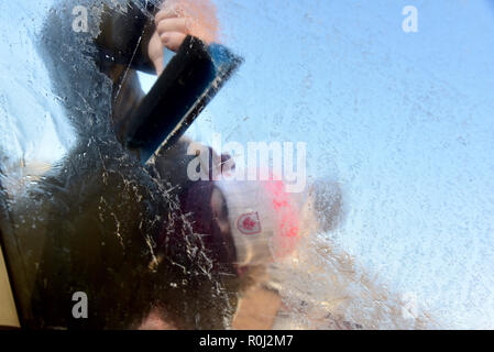 Beaucoup de pays de Galles s'est réveillé ce matin à la couche de givre de surface couvrant les pare-brise de voiture et des températures de gel. retrait de la glace d'un pare-brise de voiture Banque D'Images