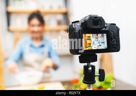 Young cute Asian girl blogger tutoriel vidéo Enregistrement de session du cours de cuisine salade à la cuisine. Blogging alimentaire ou vlogging, médias sociaux hobby Banque D'Images