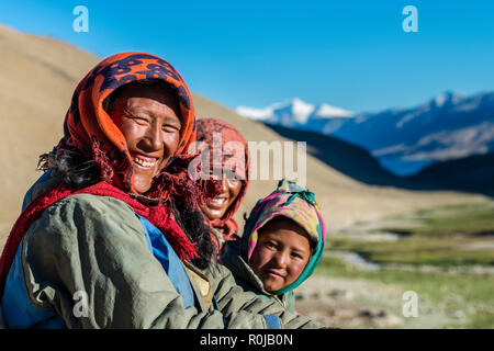 Portraits d'une famille nomade, souriant, dans la région de Tso Moriri Changtang proche avec des montagnes enneigées au loin. Banque D'Images