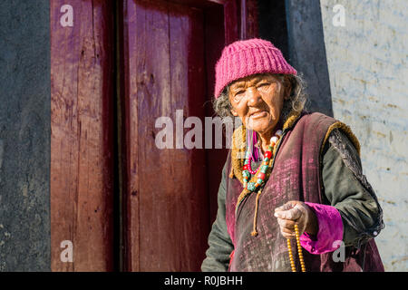 Une vieille femme marche ladakhis autour de Lamayuru Gompa, le plus ancien et le plus grand monastère existant au Ladakh, le déménagement de son beeds Mala pour religeous Banque D'Images