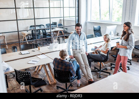 Portrait of happy young business people talking sur le lieu de travail Banque D'Images