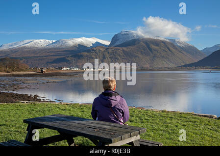 Femme seule assis à admirer la vue sur le Loch Linnhe vers, Ben Nevis, Ecosse, Royaume-Uni, Lochaber Banque D'Images