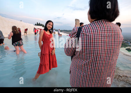 Jeune femme portant une robe rouge tout en ayant sa photo prise au château de coton à Pamukkale travertin piscines minérales, Antalya, Turquie Banque D'Images