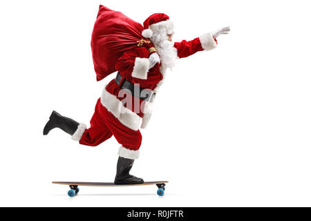 Profil de pleine longueur tourné du Père Noël équitation un longboard isolé sur fond blanc Banque D'Images