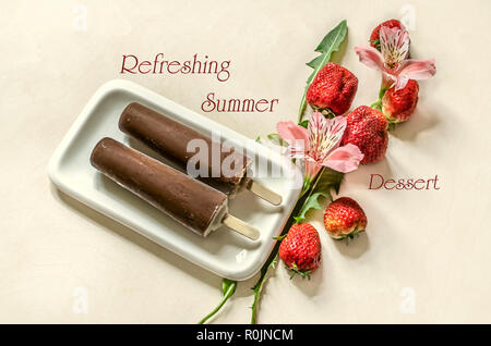 Deux glaces Popsicle on a stick couverts de chocolat se situent sur une plaque blanche près de fleurs roses avec des fraises sur un tableau blanc Banque D'Images