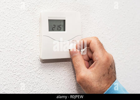 Man main réglage de thermostat à la maison. Échelle de température Celsius. Banque D'Images