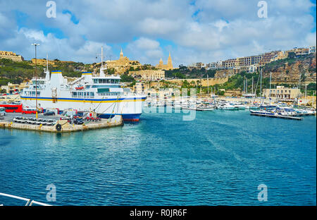 La vue sur le port de Mgarr et côtières de quartiers 13/15 de la mer, à l'église paroissiale et Chapelle Lourdes dominent la ville, Goz Banque D'Images