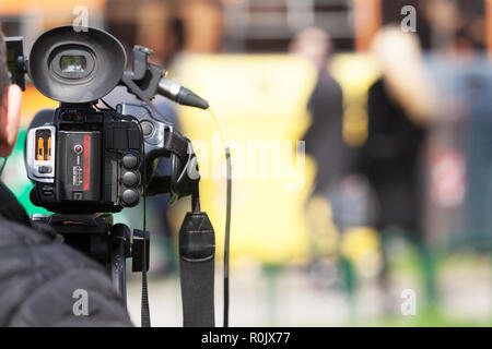Le tournage d'un vidéo sur la rue. Les gens méconnaissables dans l'arrière-plan, l'accent sur la caméra vidéo. Banque D'Images