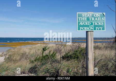 Inscrivez-vous pour rester sur le sentier et d'éviter les tiques et poison ivy à Skaket Beach à Orléans, Cape Cod, Massachusetts USA avec l'océan et un ciel bleu clair Banque D'Images