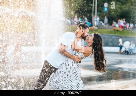 Beau gars et de belles filles, baiser sur l'arrière-plan d'une fontaine Banque D'Images