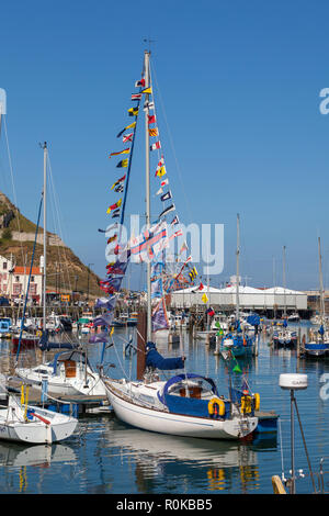 Vue d'été de port de Scarborough avec un yacht décorée de drapeaux, bateaux amarrés, ciel bleu et les manèges dans l'arrière-plan Banque D'Images