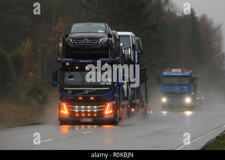 Salo, Finlande - le 2 novembre 2018 : Volvo FM car carrier de KaWa Auto Oy avec lumières DEL transporte les véhicules en circulation sur route humide sur un jour de pluie. Banque D'Images