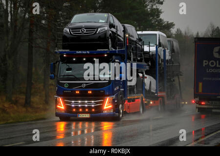 Salo, Finlande - le 2 novembre 2018 : Volvo FM car carrier de KaWa Auto Oy avec cool lumières DEL transporte véhicules le long route mouillée sur jour de pluie en Finlande. Banque D'Images