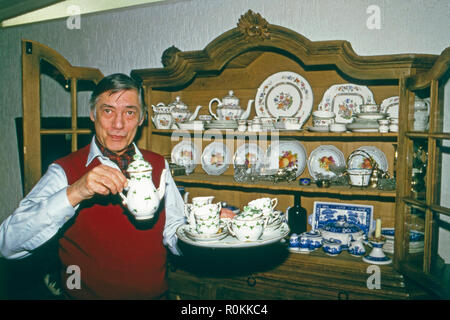 Peter René Körner, acteurs et actrices deutscher und vor seinem Sänger, dans Porzellanschranki Rösrath bei Köln, Deutschland 1984. L'acteur et chanteur allemand Peter René Koerner avec son placard plein de Chine à Roesrath, près de Cologne, Allemagne 1984. Banque D'Images