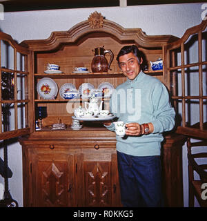 Peter René Körner, acteurs et actrices deutscher und vor seinem Sänger, dans Porzellanschrank Rösrath bei Köln, Deutschland 1971. L'acteur et chanteur allemand Peter René Koerner avec son placard plein de Chine à Roesrath, près de Cologne, Allemagne 1971. Banque D'Images