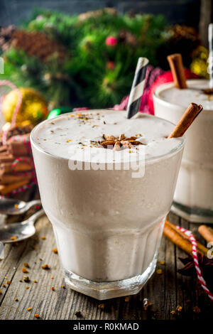 Doux Noël boisson froide, de lait de poule milkshake dans deux verres de cannelle et anis, ancien fond de bois avec des décorations de noël copy space Banque D'Images