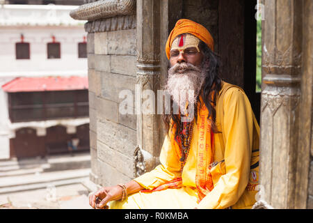 Un Sadhu se trouve dans l'un des temples à l'ensemble du temple de Pashupatinath, Katmandou, Népal Banque D'Images