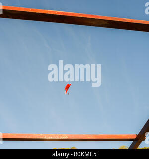 Vol d'une personne à l'aide d'un parachute sur le fond du ciel bleu, capturé en Caparica, Portugal Banque D'Images