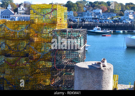 Casiers à homard empilés par le bord du quai à côté d'une paire de chaussures abandonnées Banque D'Images