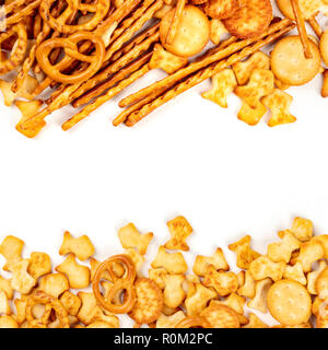 Un assortiment de sel des craquelins, des bâtons, des bretzels, et poissons, tourné par le haut sur un fond blanc avec une place pour le texte. Des collations, formant partie mix Banque D'Images