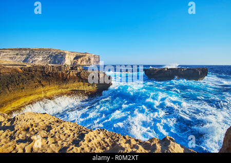 Le petit havre naturel pittoresque avec roches massives et mousseux eaux bleu azur de la mer, côte Dwejra, San Lawrenz, l'île de Gozo, Malte. Banque D'Images