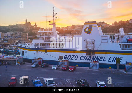 13/15, Malte - 15 juin 2018 : Les derniers rayons de soleil sur le Fiery Mgarr Harbour avec vue sur transbordeur roulier sur le premier plan, le 15 juin à G Banque D'Images