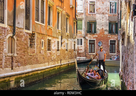 Venise, Italie - 22 août 2018 : Gondola gouverné par un gondolier dans une rue étroite du canal de Venise Banque D'Images