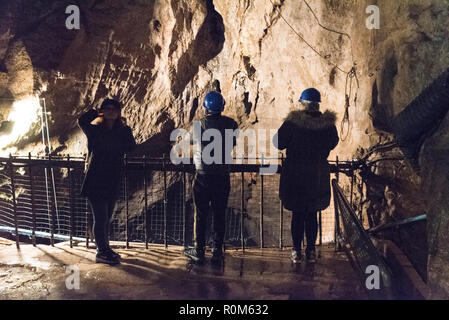 Un groupe de visiteurs portant des casques de sécurité, vers le bas par les pairs une chute verticale de 20 mètres de l'Abîme dans les 250 ans à la mine de plomb Speedwell cavern n Banque D'Images