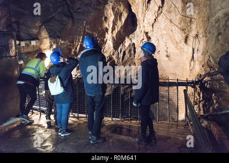 Un groupe de visiteurs portant des casques de sécurité, vers le bas par les pairs une chute verticale de 20 mètres de l'Abîme dans les 250 ans à la mine de plomb Speedwell cavern n Banque D'Images
