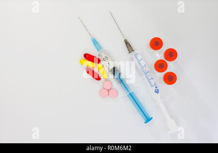 Médicament comprimés ou gélules avec seringue sur fond blanc. Prescription de médicaments pour le traitement des médicaments. Banque D'Images