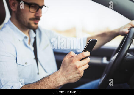 Homme pilote à l'aide de smart phone in car modern Banque D'Images