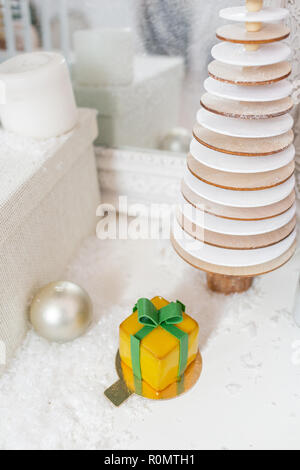 Mini Pâtisseries Dessert Mousse jaune avec vitrage. Sous la forme de boîte-cadeau, de rubans de chocolat. Gâteau européen moderne. La cuisine française. Thème de Noël Banque D'Images