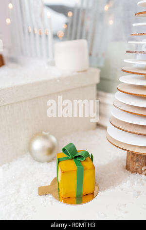 Mini Pâtisseries Dessert Mousse jaune avec vitrage. Sous la forme de boîte-cadeau, de rubans de chocolat. Gâteau européen moderne. La cuisine française. Thème de Noël Banque D'Images
