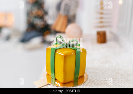 Mini Pâtisseries Dessert Mousse jaune avec vitrage. Sous la forme de boîte-cadeau, de rubans de chocolat. Gâteau européen moderne. La cuisine française. Thème de Noël Banque D'Images