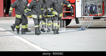 Italia, Italie - 10 mai 2018 : les pompiers italiens transporter un blessé sur le brancard lors d'un exercice de sauvetage en bordure de la pratique Banque D'Images