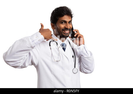 Friendly Indian male medic parlant au téléphone et faire m'appeler plus tard avec les doigts geste isolé sur fond blanc Banque D'Images